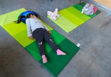 [fot. Katarzyna Waagner] Zajęcia w Centrum Aktywności Rodzin. Dwie dziewczynki wykonują ćwiczenia na matach gimnastycznych.  - powiększ