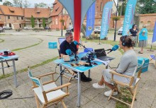 Piątek pełen wrażeń - Mobilne Studio Radia Gdańsk na dziedzińcu przy kościele pw. WNMP w Żukowie - przy stoliku na którym są mikrofony ksiądz Proboszcz parafii WNMP w Żukowie Robert Jahns oraz Magda Manasterska z Radia Gdańsk. - powiększ
