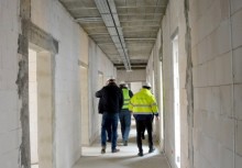 3 osoby idą korytarzem w rozbudowywanej części Urzędu Gminy w  Żukowie - powiększ