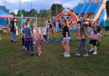 Grupka dzieci bawiących się w kółku na festynie. - powiększ