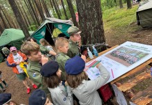 Harcerze podpisują się pod zdjęciem grupowym - powiększ