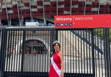 Aleksadra Nosel w czerwonej sukni przed bramą stadionu - powiększ