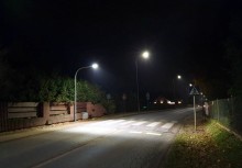 Ulica nocą. Widać oświetlone wyniesione przejście dla pieszych. - powiększ