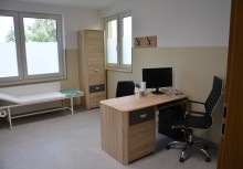 Gabinet lekarski, widać między kozetkę lekarską, biurko, komputer - powiększ