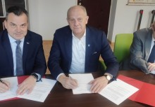 Trzy osoby, dwie podpisują umowy - powiększ