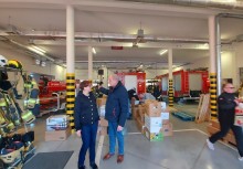 Dwie osoby rozmawiają w remizie straży pożarnej - powiększ
