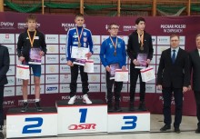 Na podium czworo sportowców, przy nich trzy osoby - powiększ