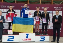 Na podium czworo sportowców, przy nich dwie osoby. Sportowcy na podium trzymają ukraińską flagę. - powiększ