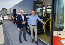 Burmistrz i jego zastępca stoją przy autobusie - powiększ