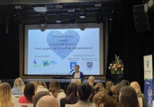 Uczestnicy konferencji 'Zrozumieć autyzm' na widowni oraz prowadząca konferencję - powiększ
