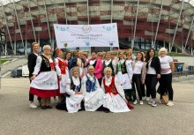 Około 20 kobiet z Gospodyń Wiejskich w Chwaszczynie, za nimi stadion. - powiększ