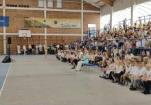 Uczniowie i goście podczas inauguracji roku szkolnego w Żukowie – wydarzenie odbywa się w hali sportowej z banerem gminy w tle. - powiększ