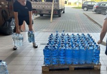 Wolontariusze rozładowują zgrzewki wody podczas akcji pomocowej – przygotowanie darów dla potrzebujących. - powiększ