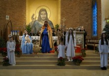 Kilka osób na schodach przed ołtarzem w kościele - powiększ