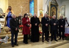 Kilka osób przed ołtarzem, przemawia Burmistrz Mariola Zmudzińska - powiększ