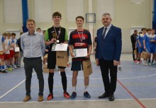 Na zdjęciu czterech mężczyzn, z czego dwóch stojących na środku to zawodnicy futsalu - powiększ
