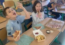 Chłopczyk i Dziewczynka zajadający sie pizzą i frytkami . - powiększ
