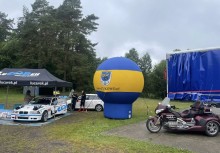 Po lewej stronie samochód, na środku balon z logo Gminy Żukowo a po prawej motocykl. - powiększ