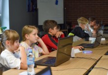 Dzieci siedzące przed monitorami na zajęciach . - powiększ