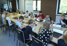 Grupa dzieci siedzących przy stole. - powiększ