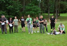 Grupa ludzi w różnej kategorii wiekowej stojących na łące. - powiększ