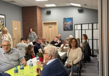 Ludzie w świetlicy siedzą przy stołach - powiększ