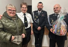 Dwie kobiety i dwóch mężczyzn, jeden z nich trzema w ręku kosz prezentowy - powiększ