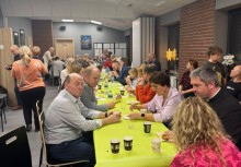 Ludzie w świetlicy siedzą przy stołach - powiększ