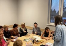 Na zdjęciu grupa kobiet siedząca przy stole podczas warsztatów.  - powiększ