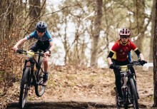 Dwóch chłopków w kaskach podczas wyścigu rowerowego.  - powiększ