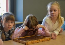 dzieci przyglądające się ramkom pszczelarskim - powiększ