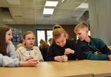 Czwórka dzieci przy stole. Jedno dziecko podczas degustacji miodu - powiększ