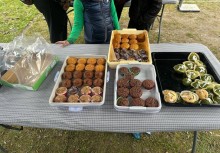 Na zdjęciu stół, na którym są pojemniki z mufinkami. - powiększ