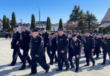 Grupa strażaków w galowych mundurach podczas przemarszu.  - powiększ