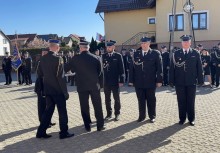 Grupa strażaków w mundurach galowych podczas uroczystości na placu.  - powiększ