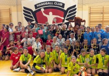 Zdjęcie grupowe, w tle baner z napisem 'HANDBALL CLUB'. 
