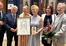 Elżbieta Pryczkowska, dyrektor SP w Tuchomiu, z nagrodą „Bëlny szkólny” – wyróżnienie za zaangażowanie w nauczanie języka kaszubskiego. 6 osób pozuje do zdjęcia  - powiększ