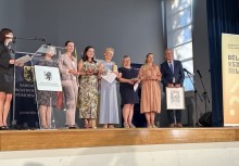 Laureaci konkursu „Bëlny szkólny” na scenie – wspólne zdjęcie wyróżnionych nauczycieli i organizatorów uroczystości. - powiększ