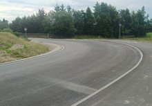 Nowy odcinek ul. Chłopskiej w Żukowie – świeżo położony asfalt i łuk drogi w otoczeniu zieleni. - powiększ