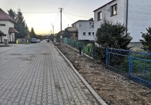 Ulica z kostki obok rozkopany pas ziemi, budowa chodnika. - powiększ
