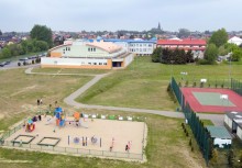 Widok z góry na plac zabaw, szkołę i boisko - powiększ