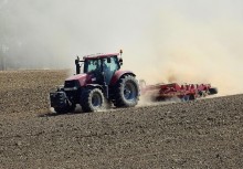 Traktor na polu podczas suszy - powiększ