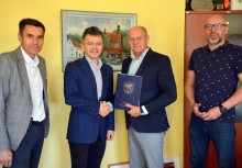 Przewodniczący Rady Miejskiej w Żukowie, Wykonawca inwestycji, Burmistrz Gminy Żukowo, Kierownik Referatu inwestycji w Urzędzie Gminy w Żukowie. Burmistrz trzyma teczkę z umową - powiększ