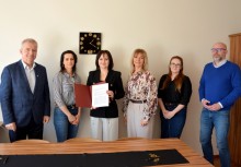 6 osób, Burmistrz Mariola Zmudzińska trzyma umowę