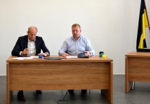 Przy biurku w sali obraz Rady Miejskiej w Żukowie podpisują umowę Burmistrz Wojciech Kankowski oraz przedstawiciel wykonawcy zadania - powiększ
