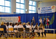 Na scenie śpiewają uczennice, przed nimi publiczność z na krzesełkach - powiększ