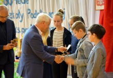 Wiceprzewodniczący Rady Miejskiej Albin Bychowski wręcza statuetkę uczniowi - powiększ