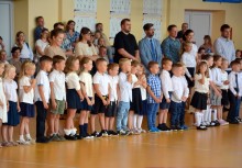 Najmłodsi uczniowie wraz z rodzicami podczas rozpoczęcia roku szkolnego – uroczystość w sali gimnastycznej szkoły podstawowej. - powiększ