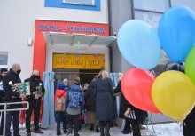 [fot. BBujnowska-Kowalska] Uczniowie wchodzą do budynku nowej szkoły w Tuchomiu. Napis nad drzwiami wejściowymi 'Witamy w nowej szkole'. - powiększ