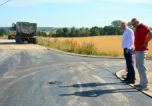 Burmistrz oraz kierownik referatu inwestycji Urzędu Gminy w Żukowie przy modernizowanej drodze - powiększ